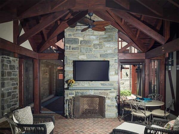 Covered outdoor living space with fireplace and television