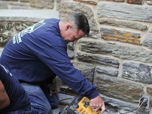 Kelly Masonry team member repairing brick