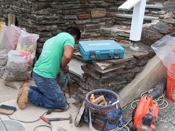 Kelly Masonry team member repairing stone steps