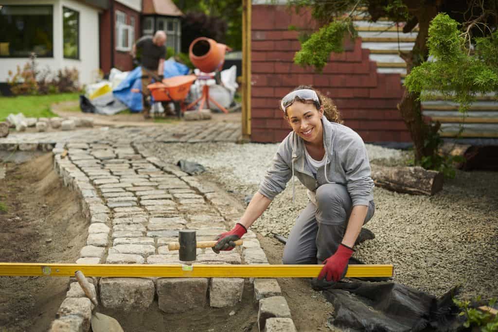 female landscape designer installing a cobble path