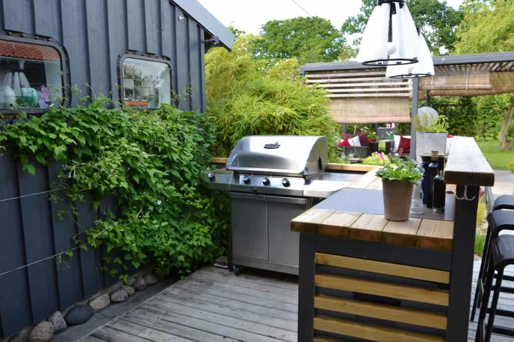 Outdoor kitchen with a stainless gas grill.